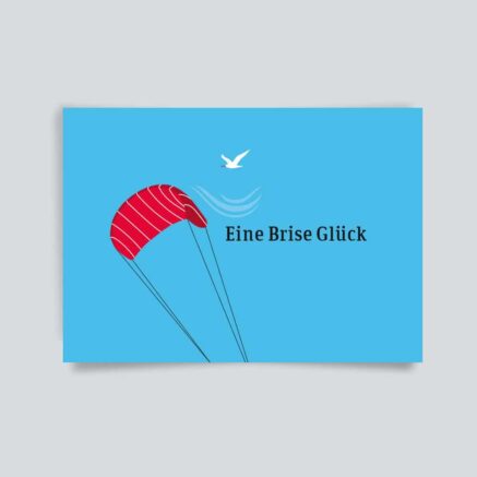 Broschüre mit rotem Paragliding-Schirm und dem Text 'Eine Brise Glück' auf blauem Hintergrund.