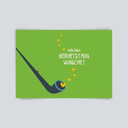 Eine Geburtstagskarte mit einer Pfeife und Herzen auf grünem Hintergrund.