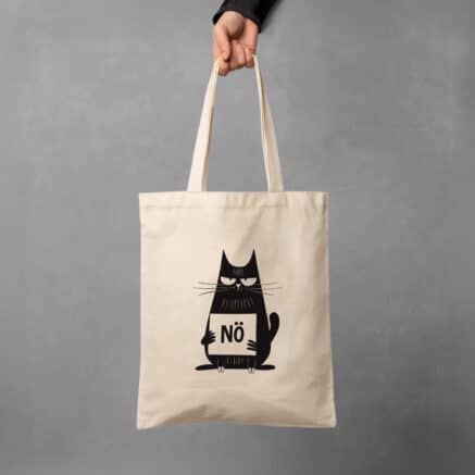Ein naturfarbener baumwollbeutel wird von einer Hand gehalten. Darauf zu sehen ist eine schwarze Katze mit einem NÖ Schild